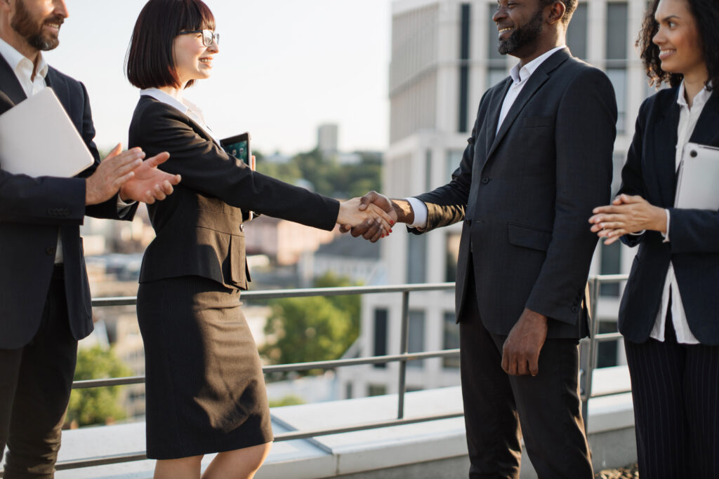 Two business professionals shaking hands, demonstrating the power of face-to-face engagement.